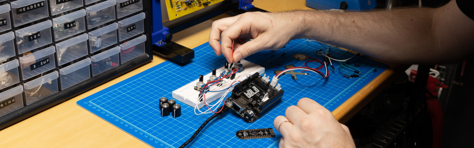 Hands working with a Bela system on a workbench